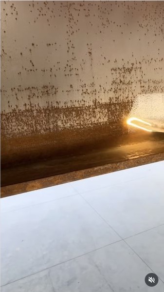 Alta Laser removing rust from a steel beam, with the cleaned pass visible beside the rusty surface